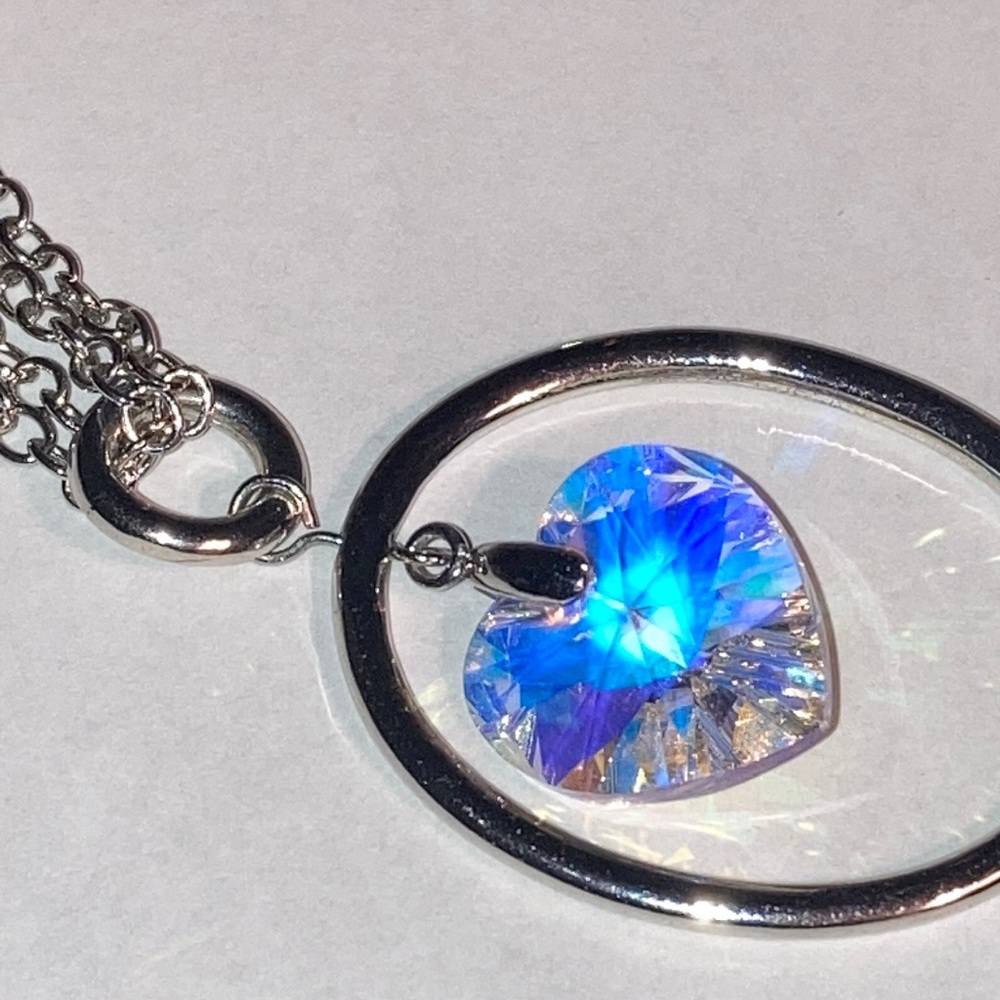 White crystal heart drop necklace on a silver tone double chain